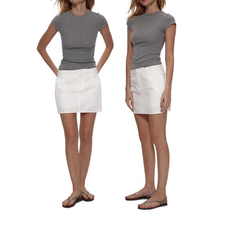 The grey Essential Tee worn with a white mini skirt and sandals