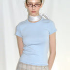 The Essential Tee in baby blue worn with a checked skirt and a silk scarf