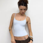 Front view of the white Studio Tank worn with brown low-rise trousers