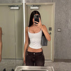 Model wearing the EYE Archive Studio Tank in white with dark brown low-rise jeans