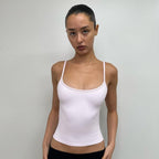 Front view of the Studio Tank in pale pink, worn with a black maxi skirt