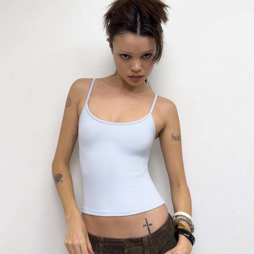Front view of the white Studio Tank worn with brown low-rise trousers